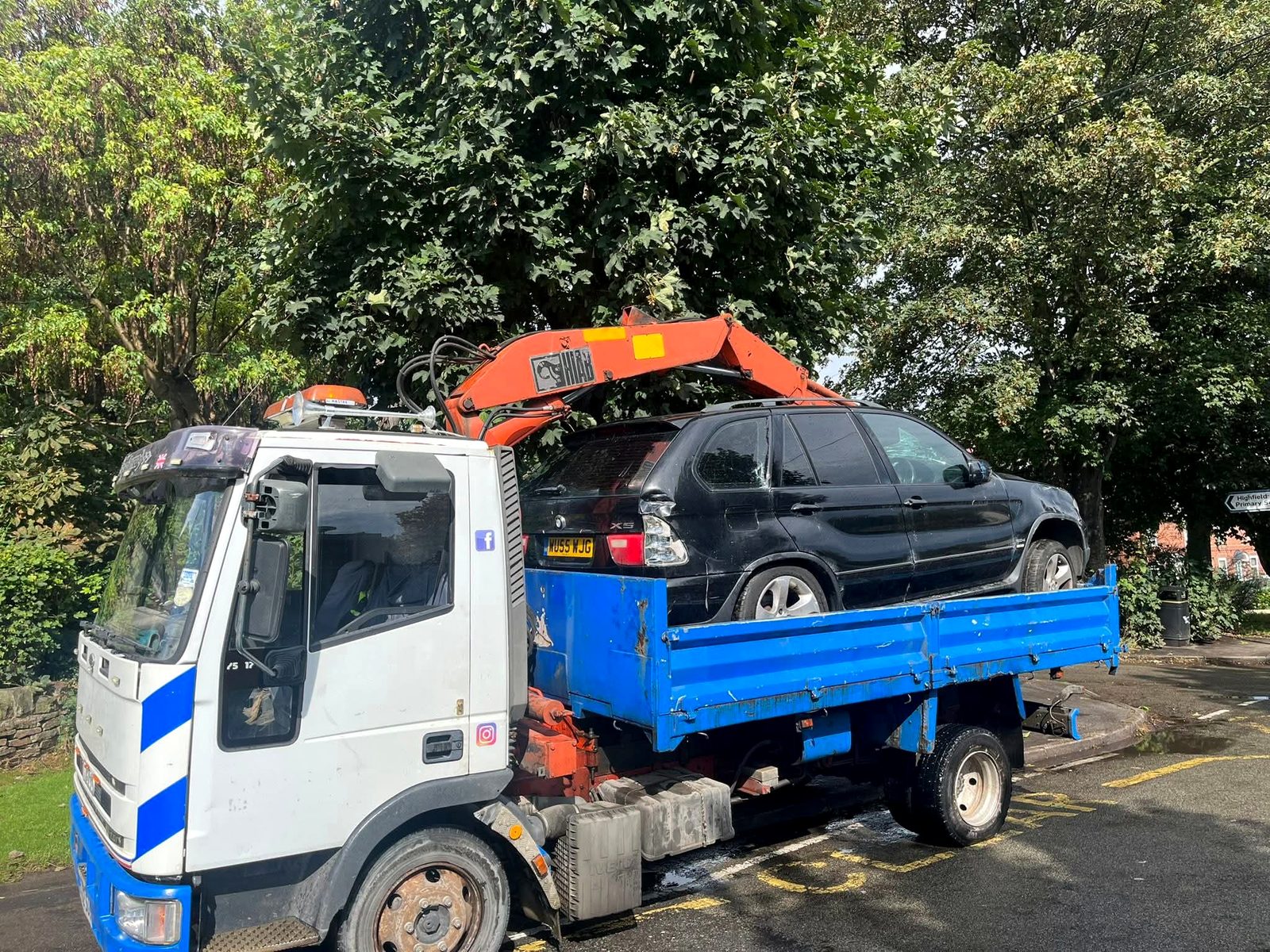 Vehicle being collected by crane truck